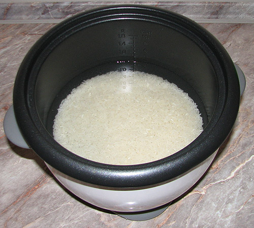 Rizs vízzel leöntve a rizsfőzőben